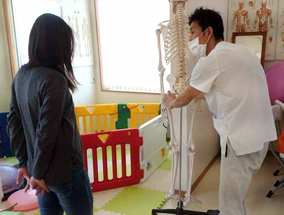 骨格図を元に施術の説明をしているイメージ